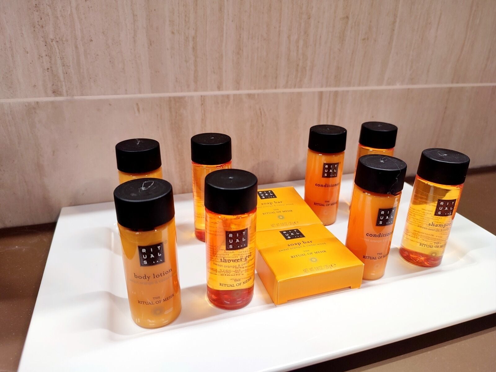 Un plateau blanc contenant divers produits de la gamme Ritual of Men, notamment une lotion pour le corps, un gel douche et un shampooing.