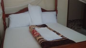 A bed with a white sheet, a leopard print blanket, and a white pillow.