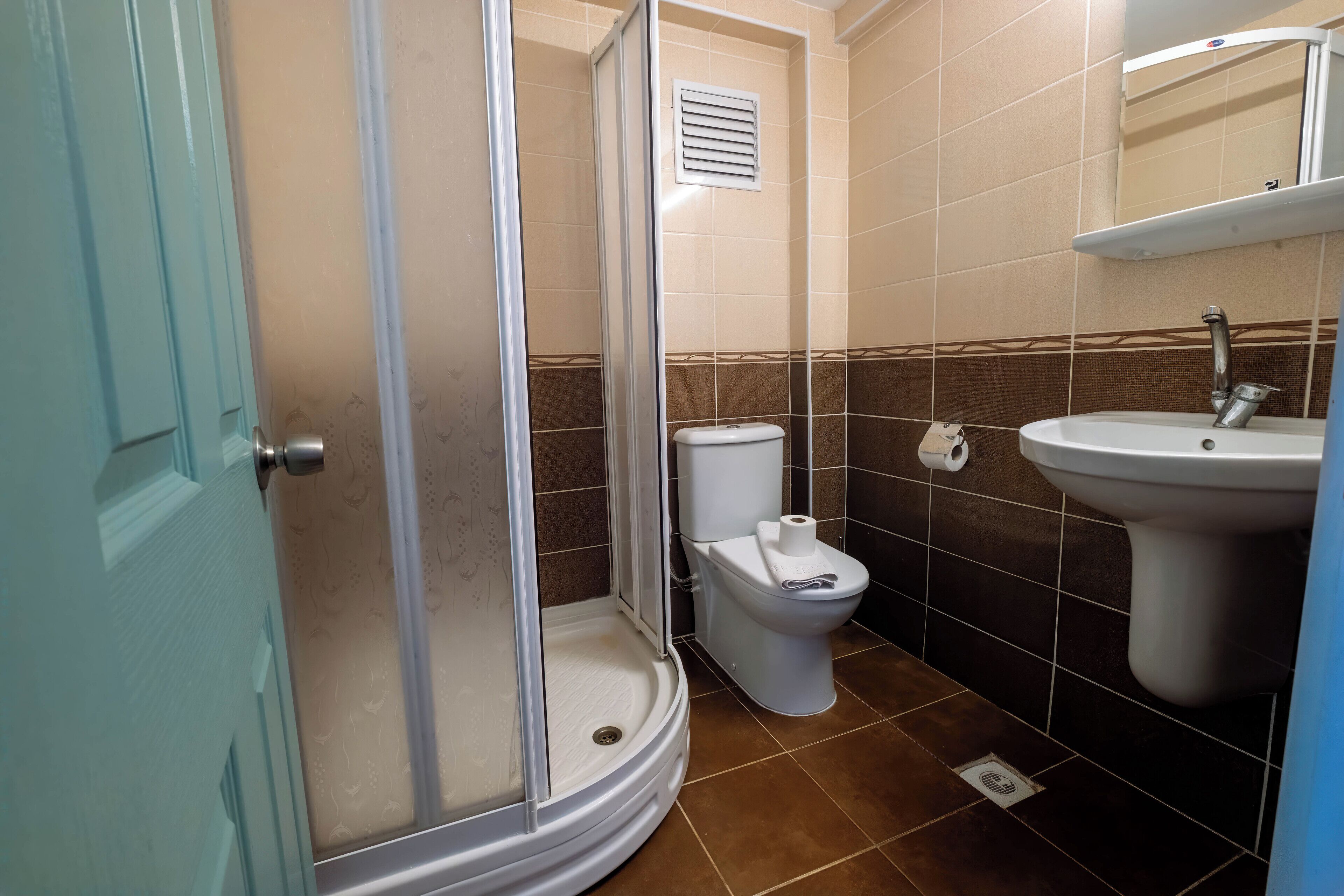 A bathroom with a shower, toilet, and sink.