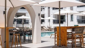 A poolside area with lounge chairs, umbrellas, and wooden tables. - Diplomat Hotel (Marmaris)