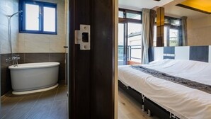 A modern bathroom with a bathtub, a shower, and a window. - Yanduo Homestay (Luodong)