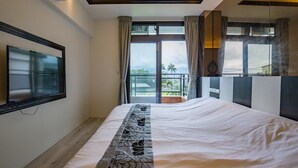 A bedroom with a large bed, a TV mounted on the wall, and a balcony with a view of the outdoors. - Yanduo Homestay (Luodong)