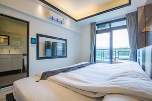 A modern hotel room with a large bed, a TV mounted on the wall, a balcony with curtains, and a view of the outdoors. - Yanduo Homestay (Luodong)