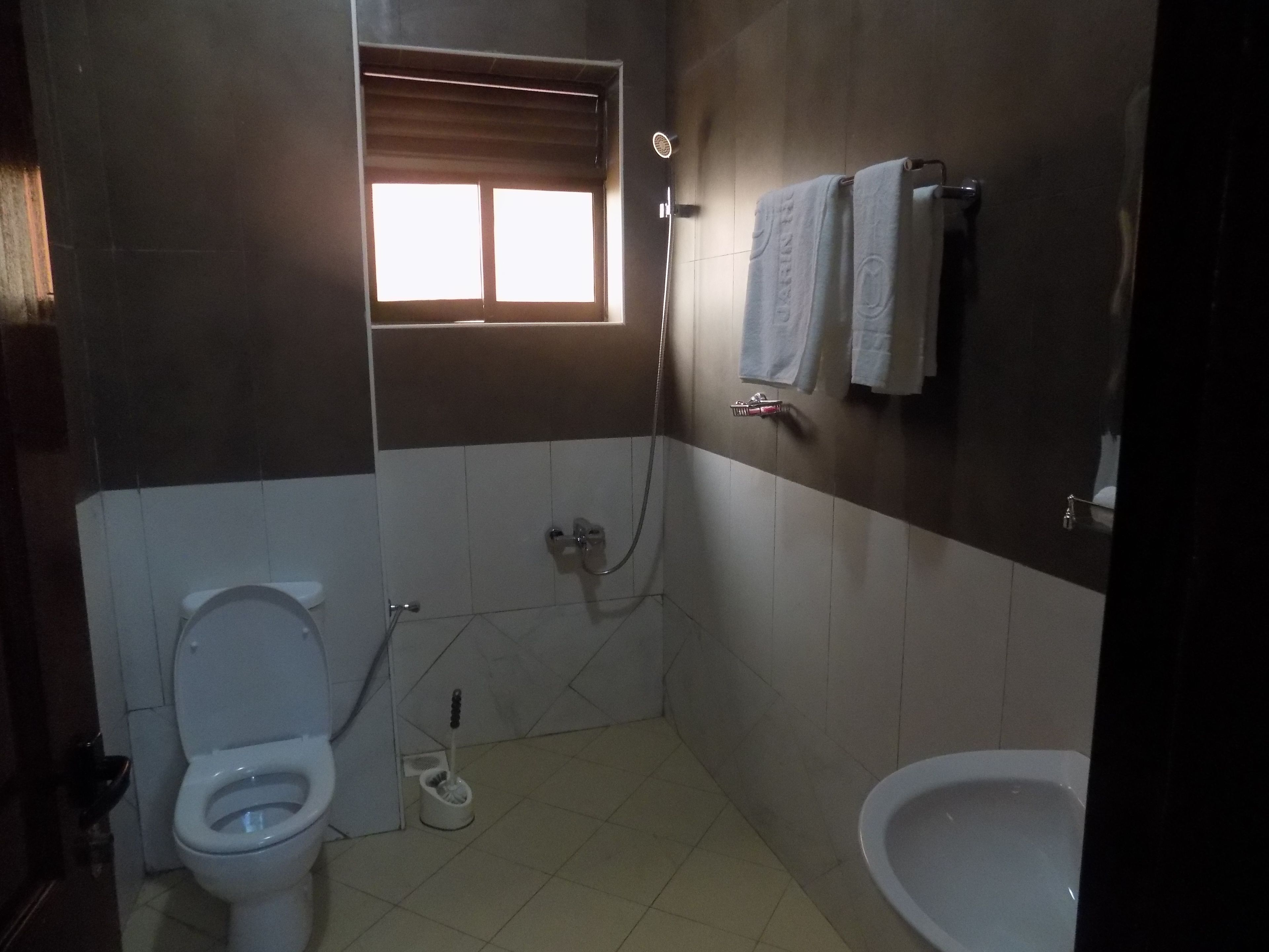A bathroom with a toilet, bidet, and a sink.