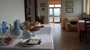 A dining area with a table set for breakfast, including a pitcher, cups, and a bowl of fruit. - B&B Severini (Morrovalle)