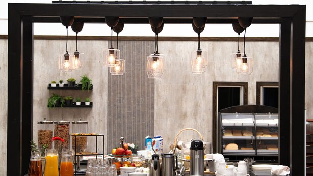 A breakfast buffet setup with various food items, beverages, and a coffee station. - Hotell Kvarntorget (Uppsala)