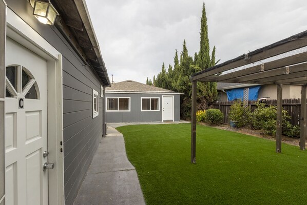 Ein Wohnhaus mit gepflegtem Rasen, einer separaten Garage und einer überdachten Terrasse.