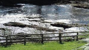 A river with a wooden fence in the foreground.