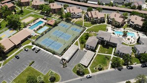 An aerial view of a residential area with multiple apartment buildings, a tennis court, and a swimming pool. - NEWLY UPGRADED Beautiful One Bedroom, One Bath, Sports Village Condo (St. George)