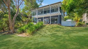 A two-story house with a covered porch and a well-maintained lawn. - Seascape - 154 Camden Head Rd Dunbogan (Dunbogan)