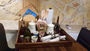 A wooden tray with various kitchen items including bottles, a tea set, and a wooden spoon. - Casa di Lavanda (Hvar)