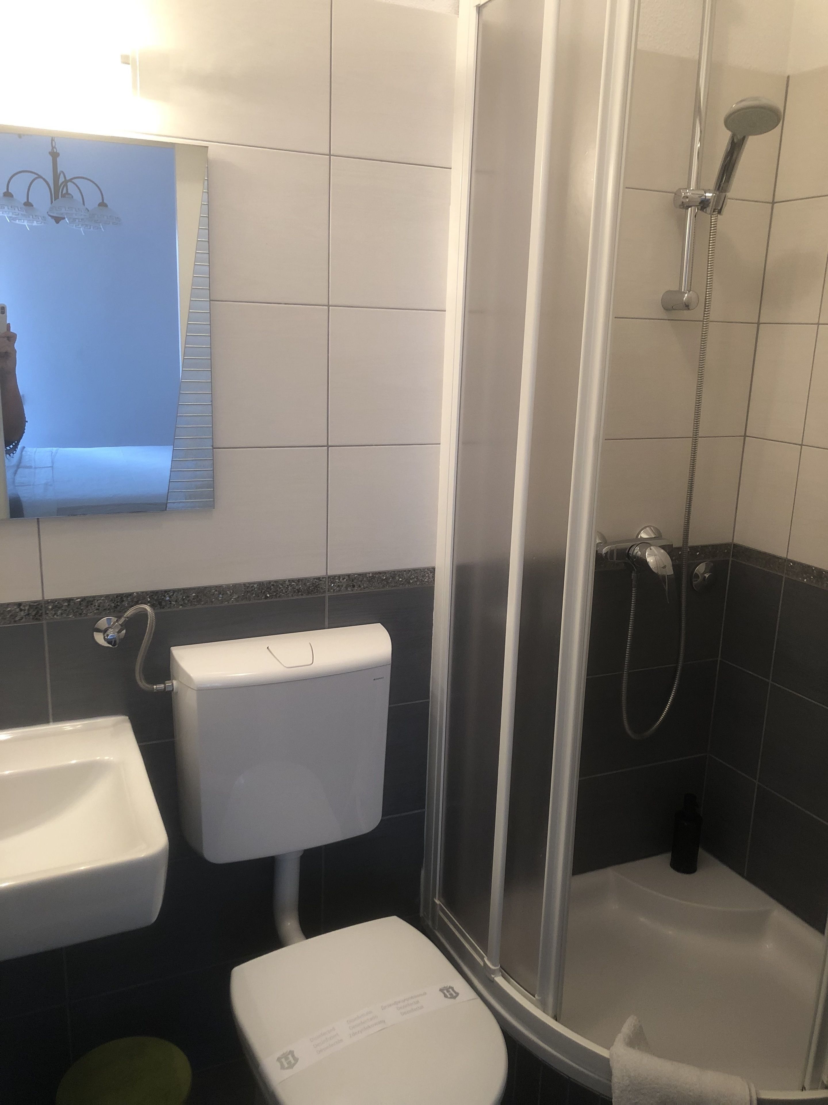 Un baño con inodoro, lavamanos y ducha.