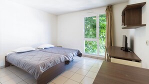 A bedroom with two beds, a desk, and a window with curtains. - Garden & City Toulon (Toulon)