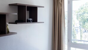 A room with a window, a door, and a shelf with a camera. - Garden & City Toulon (Toulon)