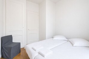 Ein Schlafzimmer mit einem Bett, zwei Kissen und einem Sessel.
