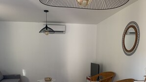 Een eethoek met een tafel, afgedekt met een tafelkleed met een citroenprint, omringd door houten stoelen.