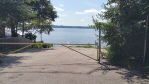 A gated entrance to a parking area with a view of a lake. - Little lake house/ Fish cabin get away (Chandler)