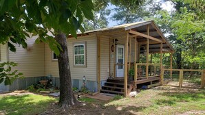 A small wooden house with a porch, a front door, and a window. - Little lake house/ Fish cabin get away (Chandler)