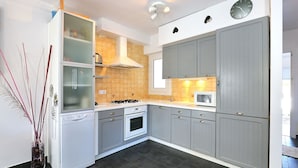 Une cuisine moderne avec des meubles gris, une cuisinière et un four à micro-ondes.