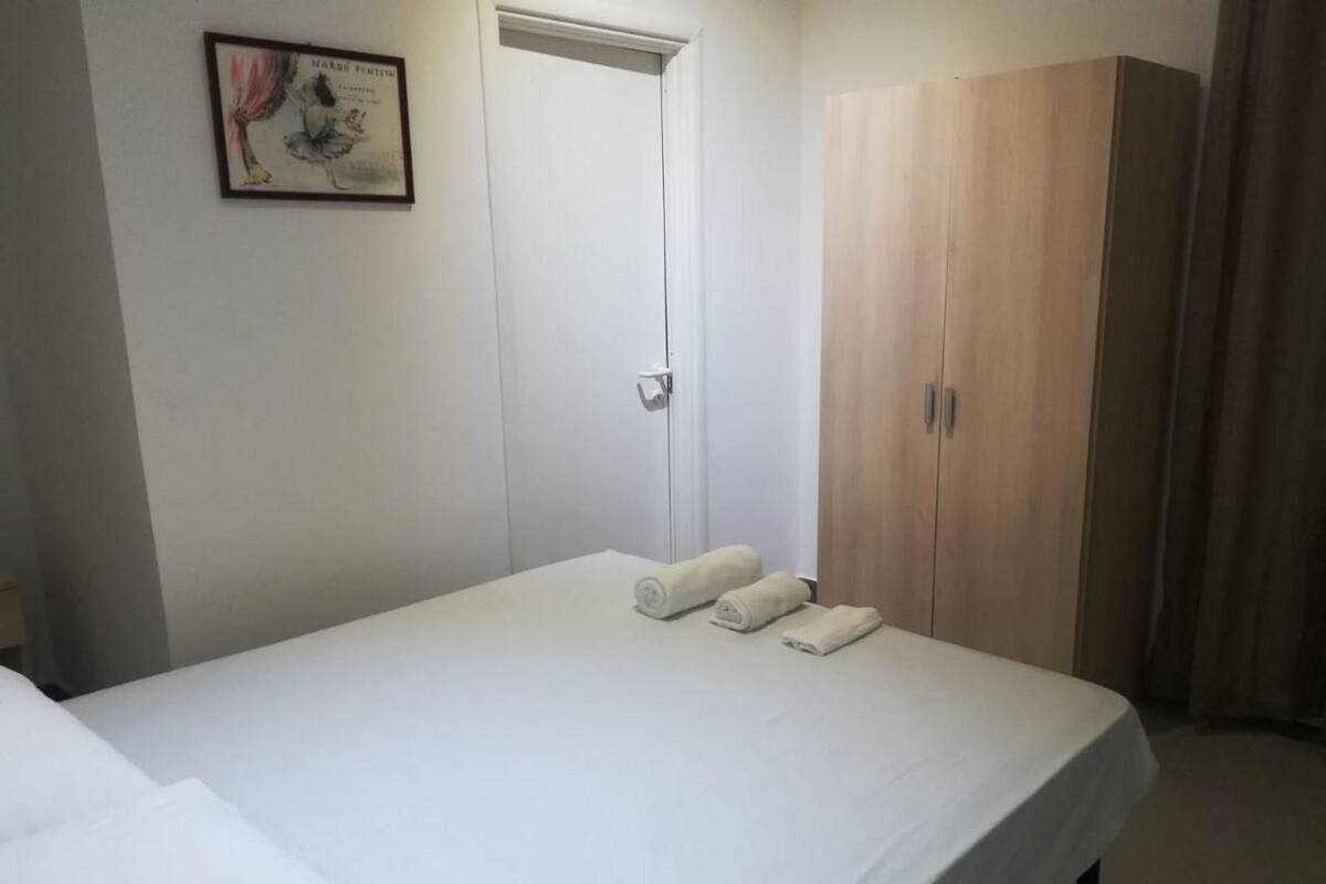 Habitación de hotel con cama, armario y puerta.