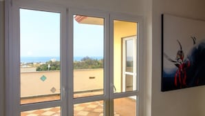 Un balcón con vista al mar y edificios.