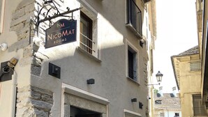 A narrow cobblestone street with a building labeled "NM NICOMAT ROOMS". - NicoMat Rooms (Domodossola)