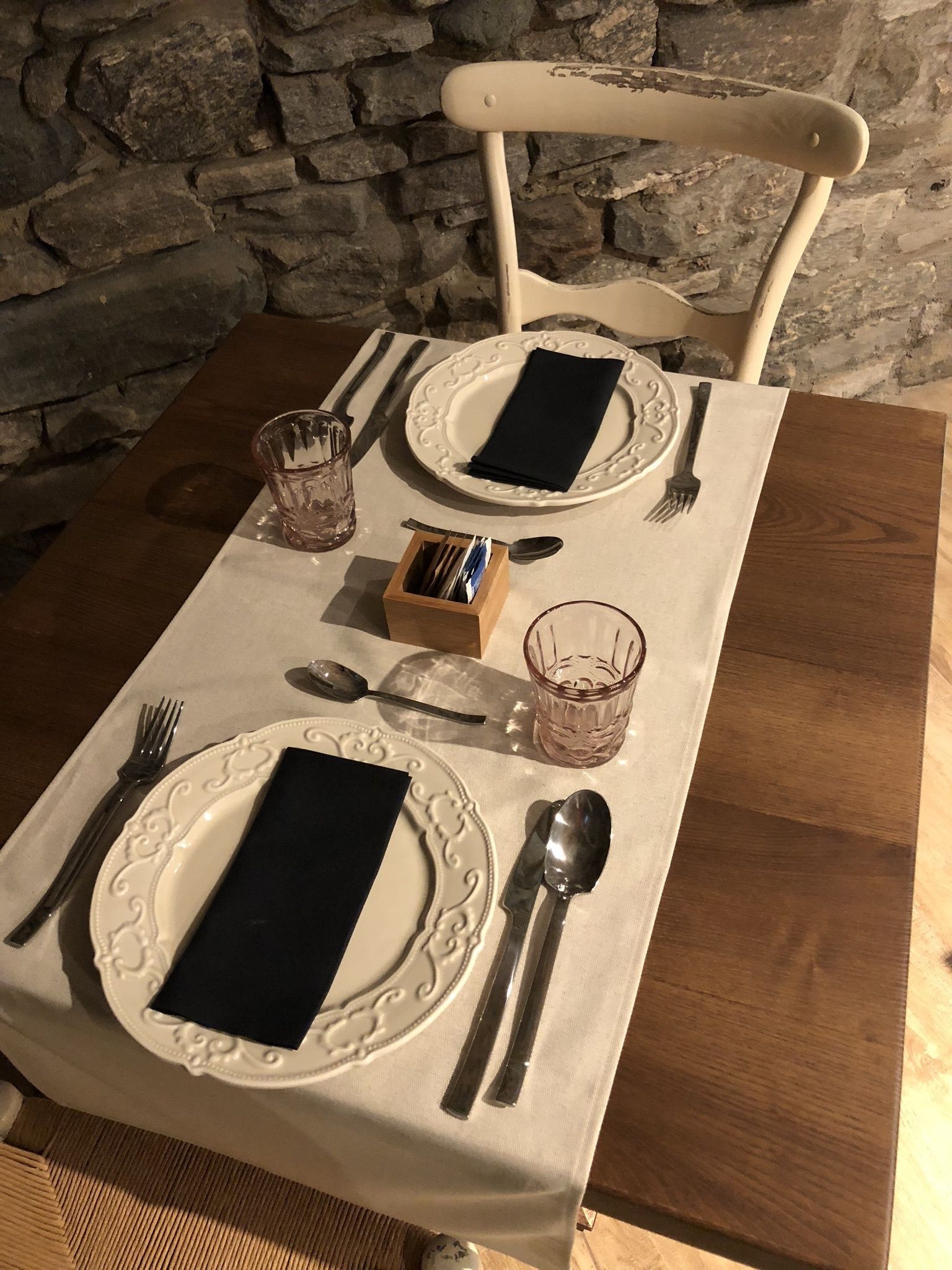 A dining table set with plates, cutlery, glasses, and napkins.