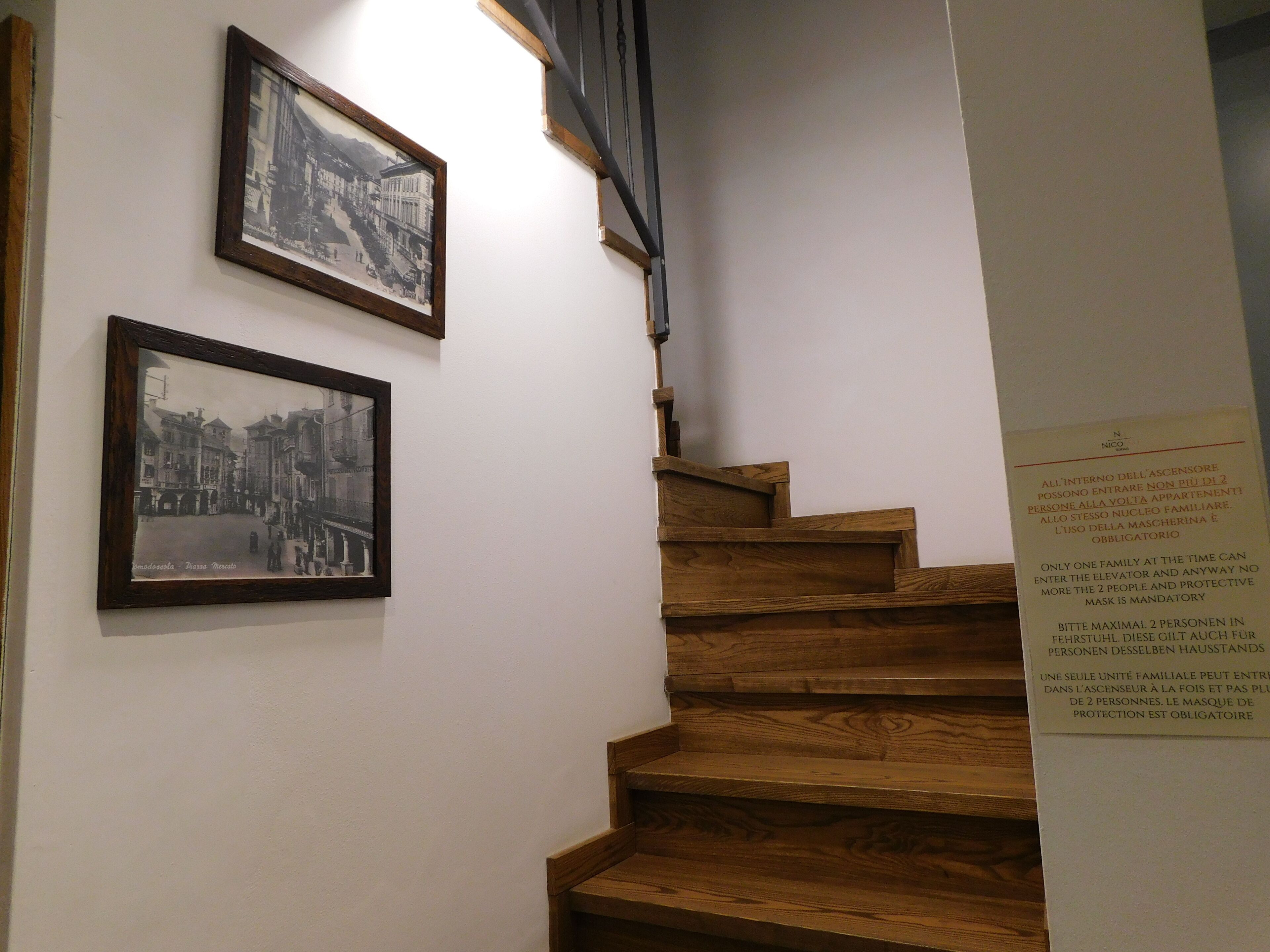 A wooden staircase with two black and white framed photographs on the wall.