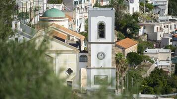 Une église blanche dotée d’un clocher et d’un dôme vert, entourée d’immeubles d’habitation.