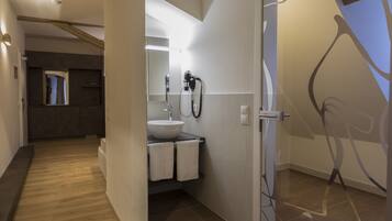 A modern bathroom with a sink, towel rack, and a hairdryer.