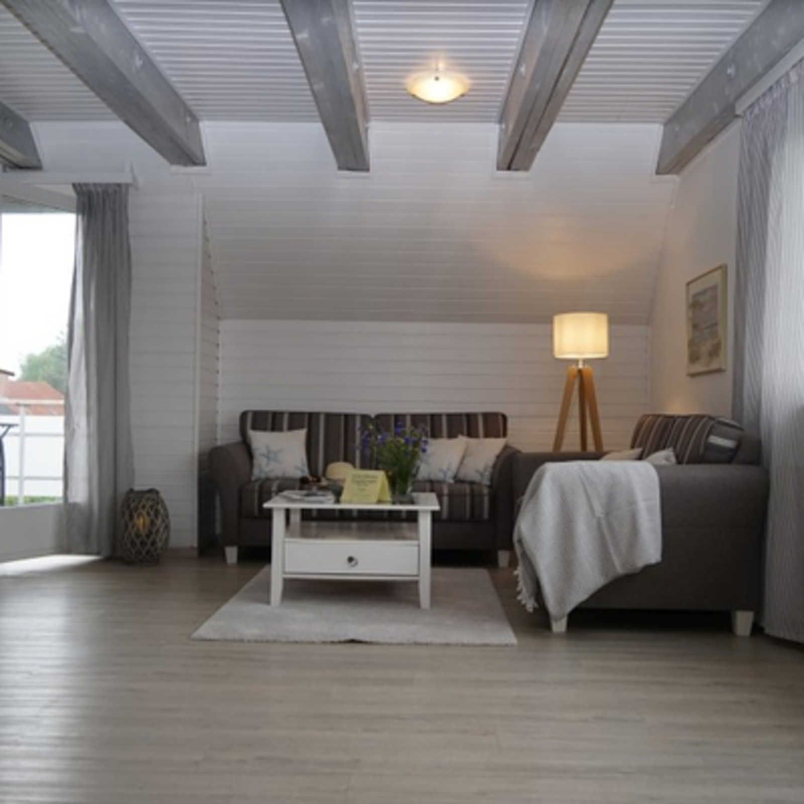 Uma sala de estar com sofá, mesa de centro e abajur.