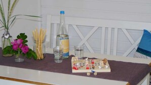 A kitchen counter with a bottle of water, a glass, a small plant, and a board game. - Apartment De lütte Stove - Apartment Woydt De lütte Stove (Kappeln)