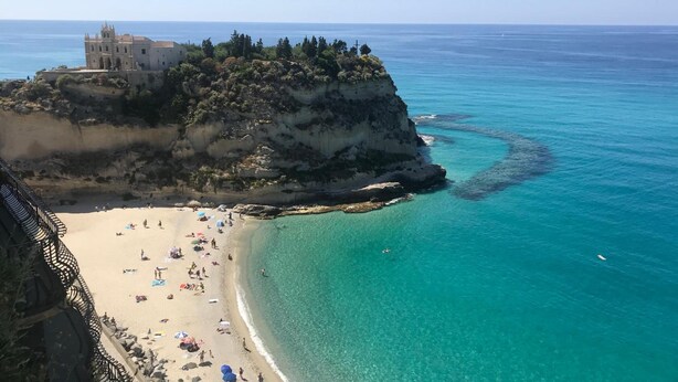 A coastal view with a beach, clear turquoise waters, and a building on a cliff. - Bed and Breakfast Casa Tropea (Tropea)