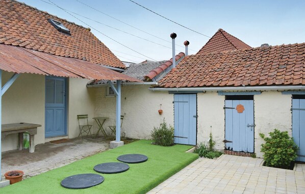 A courtyard with a tiled roof, a small seating area, and a paved walkway.