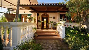 A stone pathway leading to a wooden door with a tiled roof above. - Villa Gioiello (Amalfi)