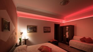 A hotel room with a bed, a small table with a lamp, and a mirror. - Villa Gioiello (Amalfi)