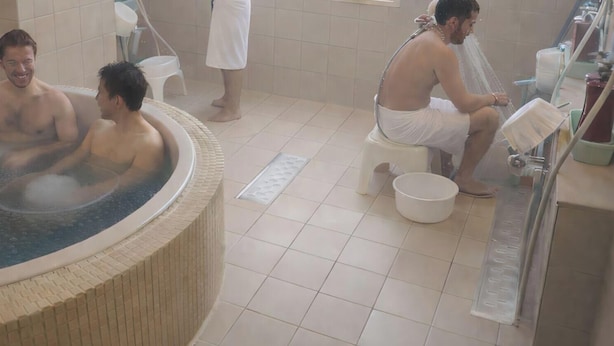Un bain à remous pouvant accueillir trois personnes, un espace douche et un sol carrelé.