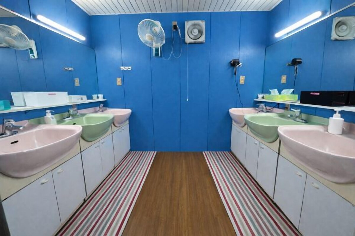 A bathroom with two sinks, a striped floor, and a blue wall.