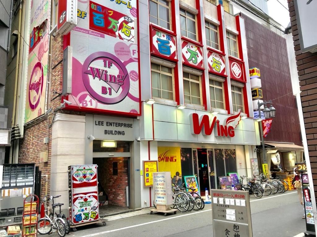 Un restaurant spécialisé dans les ailes de poulet, avec une enseigne bien visible, une devanture de magasin et des vélos garés à l’extérieur.
