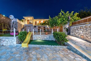 Enjoy a comfortable living space with a spacious outdoor area, stone-paved patio, and covered seating area.