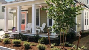 A two-story house with a front porch, a small garden, and a driveway. - Spacious Beach Retreat Near VB Boardwalk! (Virginia Beach)