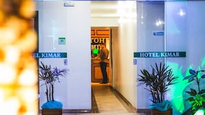 The entrance to Hotel Kimar with two doors, each labeled with the hotel's name. There are potted plants in front of the doors. - Hotel Kimar (Tramandai)