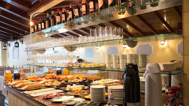 A buffet area with various food items, glasses, and bottles of beverages. - Hotel Kimar (Tramandai)