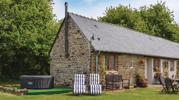 A stone house with a sloped roof, a chimney, and a small porch with outdoor seating. - 1 bedroom nice home in Fougerolles Du Plessis (Fougerolles Du Plessis)