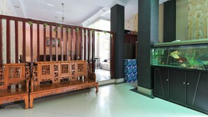Ein Zimmer mit einer hölzernen Bank, einem Aquarium und einer Wand mit Muster.