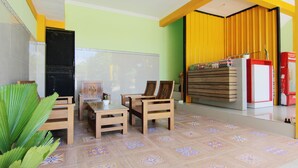 A room with a whiteboard, wooden furniture, and a tiled floor. - Losmen Alden (Parangtritis)