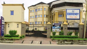 Un hôtel doté d’une grande porte d’entrée, d’une enseigne indiquant « EBEKENDY Hotels Ltd. » et d’une banderole pour « WANDY Hotels ».