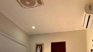 A hotel room with two beds, a window with artwork, a door, and an air conditioning unit. - Hostal  Aurora - Hostel (Santa Marta)