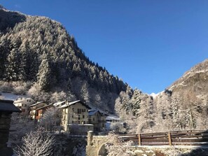 A mountain village with snow-covered buildings and a stone bridge. - Le Moulin des Aravis (Pontboset)