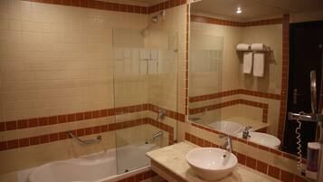 Un baño con bañera, lavabo y cabina de ducha.